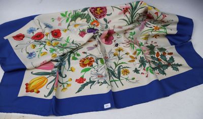 a close up of a blue and white scarf with flowers on it