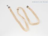 two pearl necklaces and a pair of earrings on a white surface