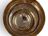 a metal bowl with a silver lid on a white surface