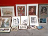 a lot of framed pictures on the floor in front of a red wall