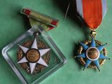 two medals and a medal on a green surface