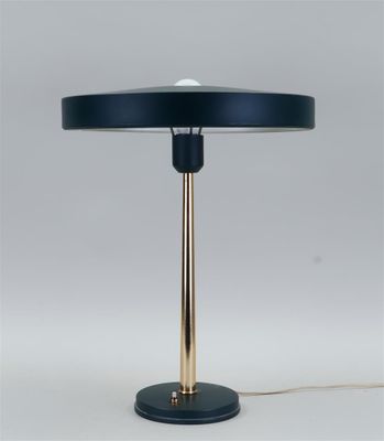 une lampe de table noire et dorée sur fond blanc