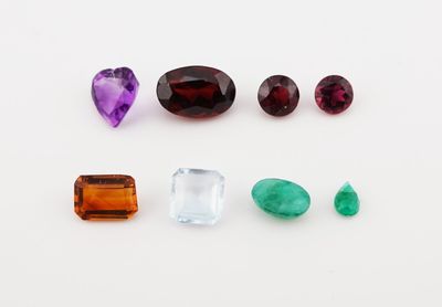 several different colored gems are arranged on a white surface