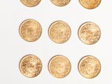 several gold coins are arranged in a triangle on a white surface