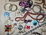 many different types of necklaces and bracelets on the table