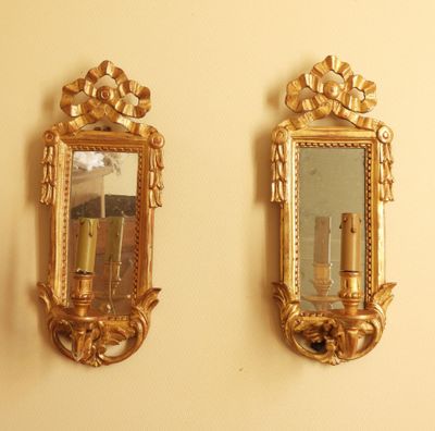 two mirrors hanging on the wall next to each other