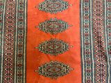 a close up of an orange rug with a pattern on it