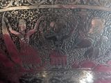 a large metal bowl with a painting on it
