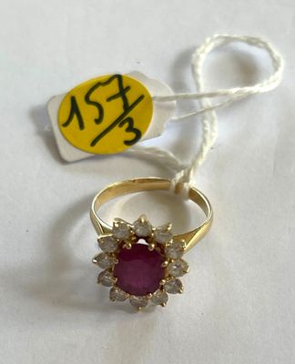 une bague en or avec une pierre rose et un cordon blanc