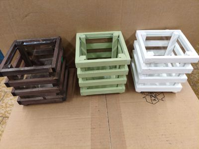trois caisses en bois posées sur un carton, lui-même posé sur une table