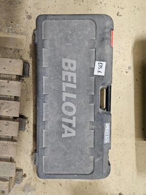 une mallette en plastique portant un nom, posée par terre