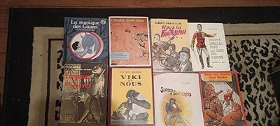 beaucoup de livres posés sur un tapis, par terre