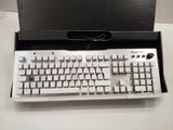 a white keyboard and a black box on a table