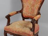 une chaise à l'ancienne dont l'assise est recouverte d'un tissu à motifs floraux