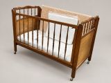a baby crib with a mattress and a pillow on it
