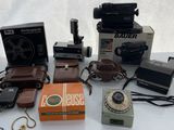 beaucoup de vieux appareils photo et d'autres objets posés sur une table