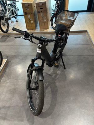 un vélo garé dans une pièce où se trouvent des cartons