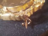 a close up of a gold watch on a blue cloth