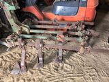 a tractor with a plow attached to it in a garage