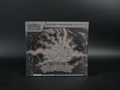 La boîte de cartes à collectionner Pokémon est posée sur une surface noire.