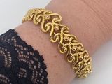 a close up of a woman ' s arm wearing a gold bracelet