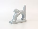 a gray cat figurine sitting on a white surface