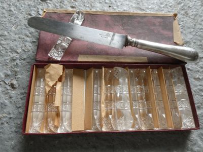 a knife in a box with a lot of empty wine glasses