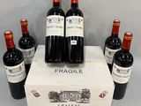 six bottles of red wine sit in a box on a table