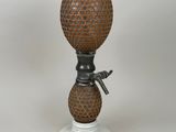a small vase with a handle on a white pedestal