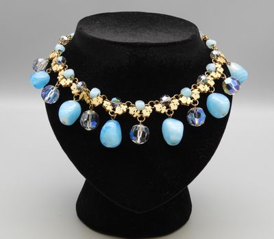 un collier composé de perles bleues sur un mannequin noir