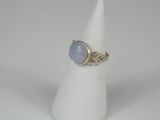 a close up of a ring with a blue stone on a white cone