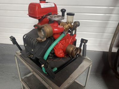 une borne d'incendie rouge posée sur un chariot métallique