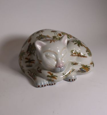 a white cat figurine sitting on a white surface