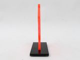 an orange and black sculpture on a black base with a white background