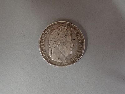 a silver coin on a table with a white background