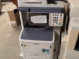 a pile of printers and other electronic equipment in a warehouse