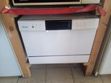 a microwave sitting on top of a dishwasher in a kitchen