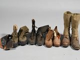 several pairs of boots are lined up in a row on a white surface