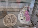 une vitrine contenant une statue de femme et un bol de nourriture