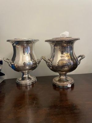 pair of silver plated urns on wooden table in room