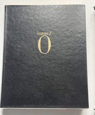 un livre noir ouvert, avec un logo doré sur la couverture