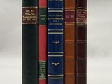 trois livres sont empilés sur une surface blanche