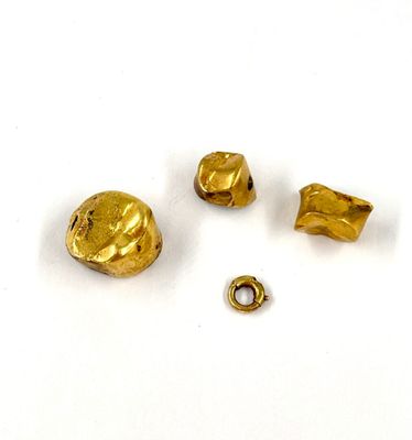 trois pièces de métal doré percées d'un petit trou au milieu