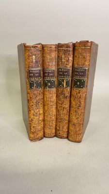 three old books sitting on top of each other on a white surface