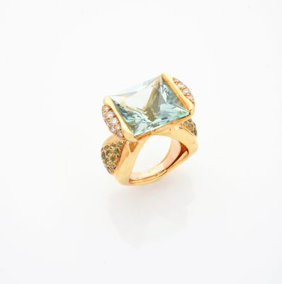 une bague en or sertie d'une topaze bleue entourée de diamants