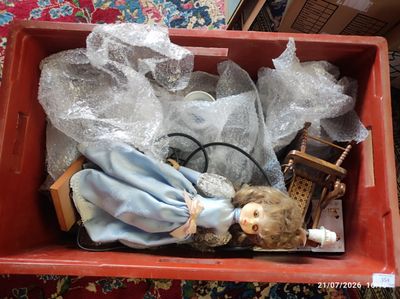a red box with a doll in it on a carpet