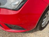 a close up of a red car parked on the side of the road