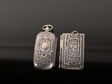 two silver lockes on a black surface with a black background