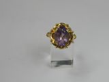 a gold ring with an amethorate stone in the center