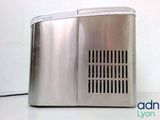 a silver toaster sitting on a table with a white wall in the background